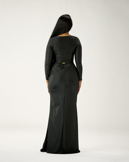 Person wearing a black long-sleeve dress with a belt on a white background