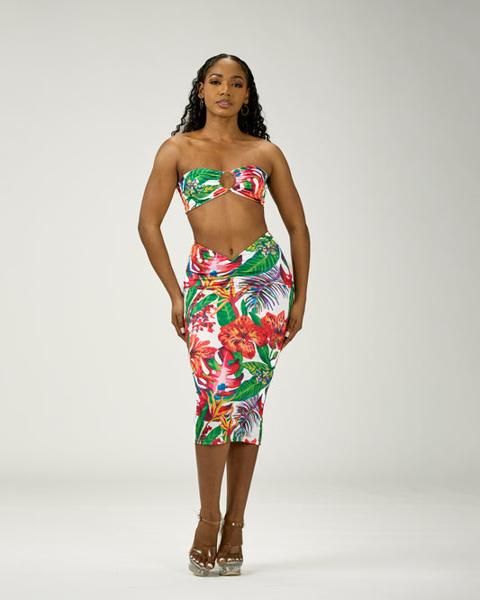 Woman wearing a colorful floral two-piece outfit on a white background